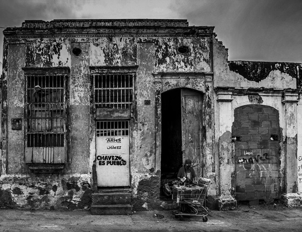 Ruined house with poor person in front in Venezuela